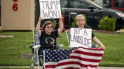 Trumpers holding signs saying, Trump won! By a landslide